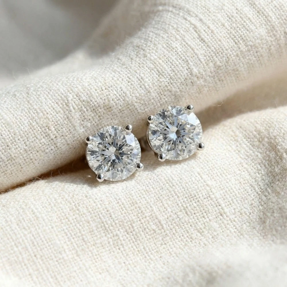 Diamond stud earrings on beige fabric